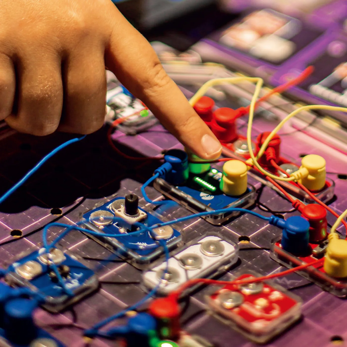 Hands building a circuit on the Reactor Rescue board